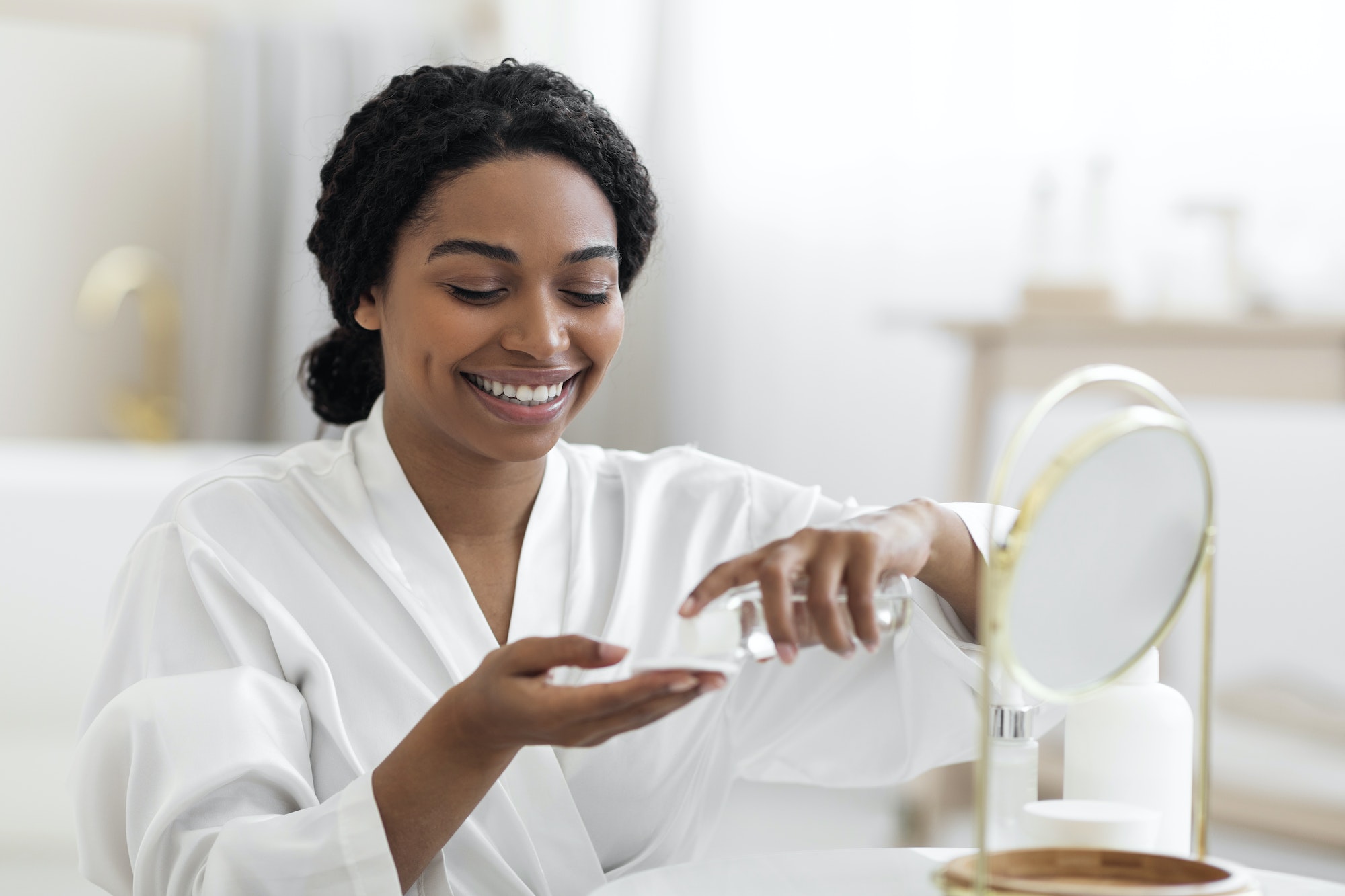 Smiling Black Female Using Cotton Pad And Micellar Water For Skincare Routine