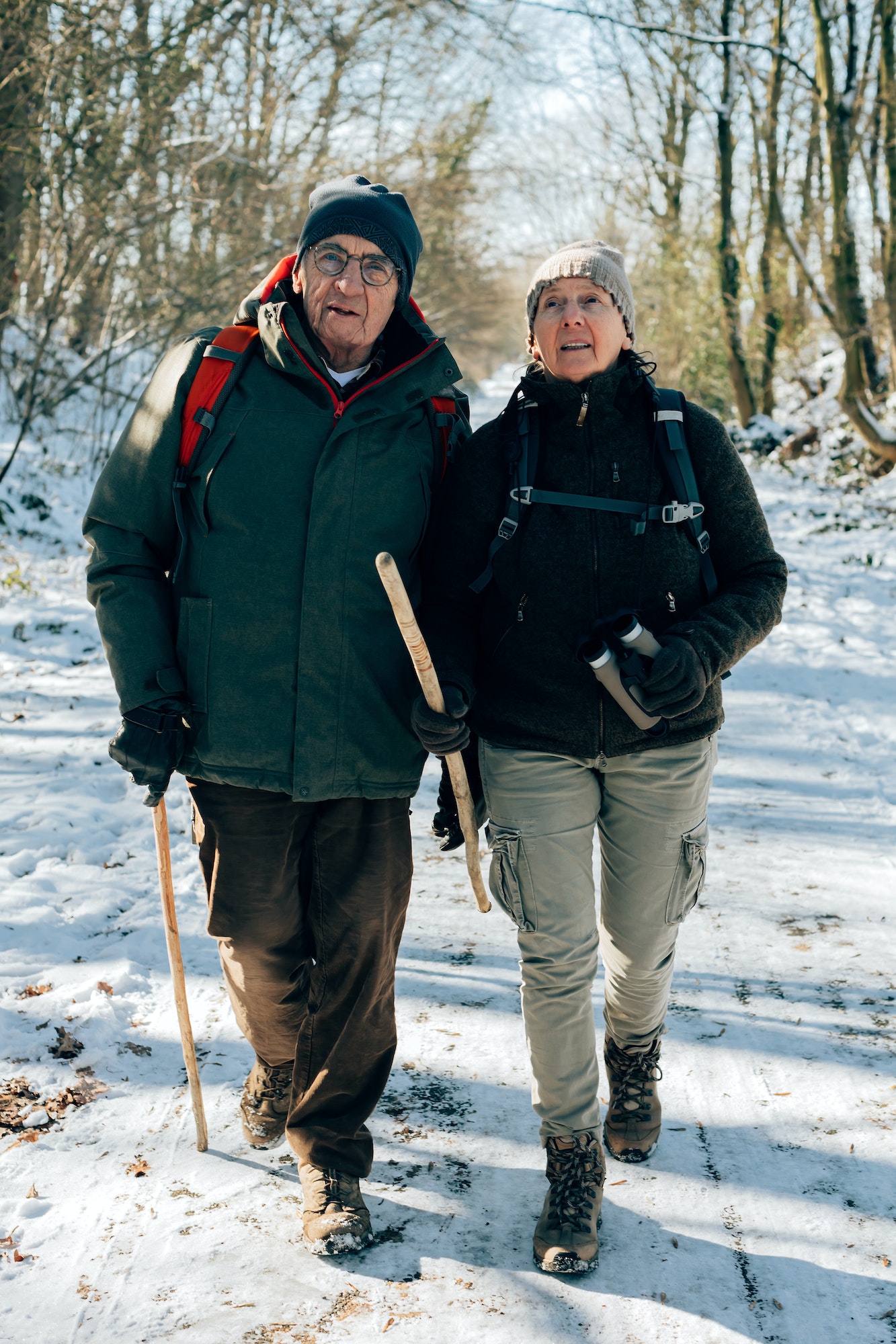 couple older people enjoy the outdoor activity - winter walking in the snowy wood